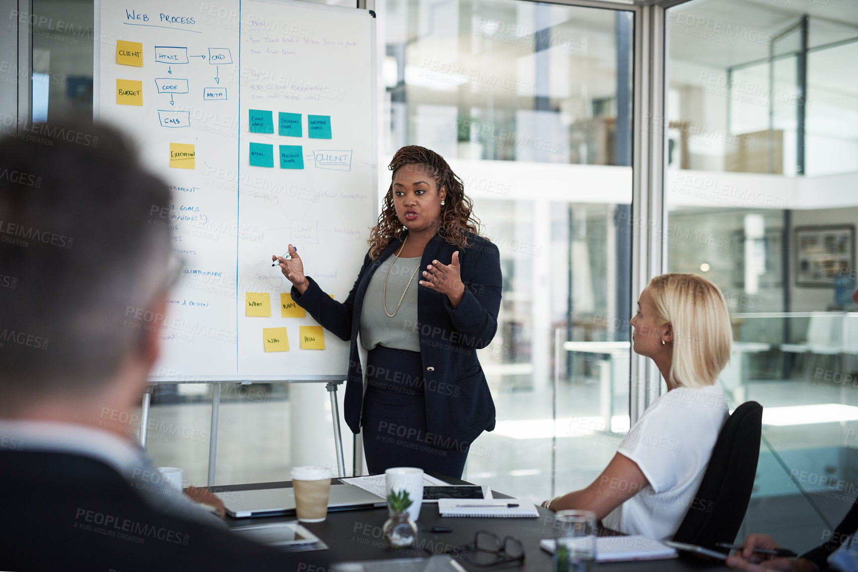 Buy stock photo Shot of a young businesswoman explaining work related stuff during a presentation to work colleagues in a boardroom