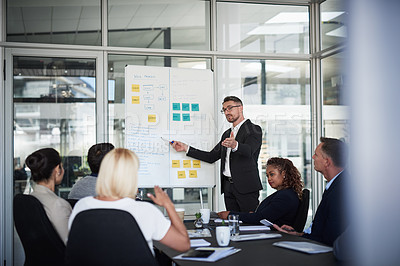 Buy stock photo Shot of a mature businessman explaining work related stuff during a presentation to work colleagues in a boardroom