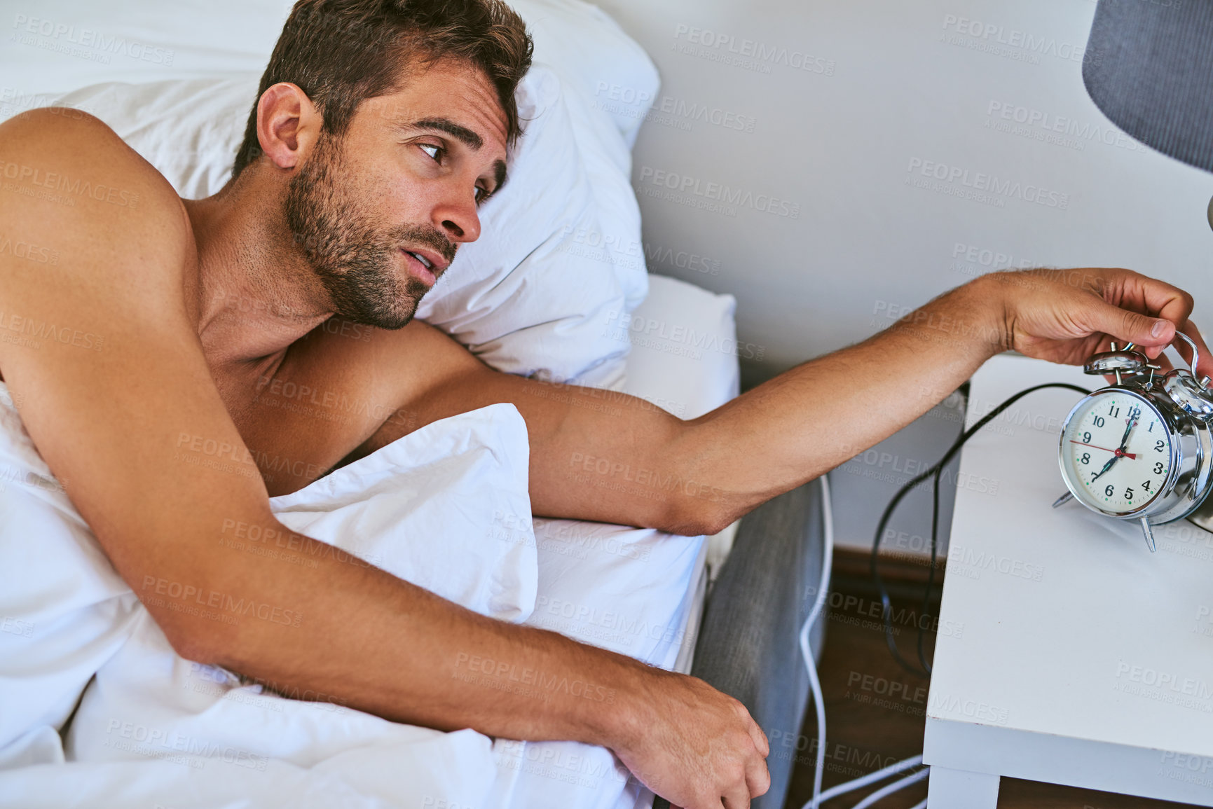 Buy stock photo Shot of a handsome young man waking up at home