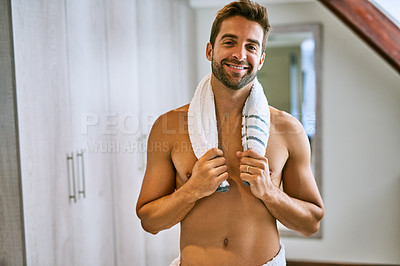 Buy stock photo Shot of a handsome young man holding a towel around his neck at home