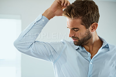Buy stock photo Shirt, stress with man smelling armpit sweat stain and indoors at his home. Hygiene or hyperhidrosis, deodorant protection for sweaty mark on clothing and young male person sweating with wet spot
