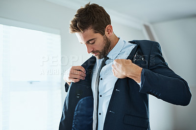 Buy stock photo Shot of a handsome young man dressing himself at home