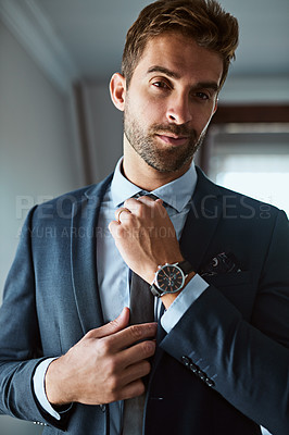 Buy stock photo Shot of a handsome young man dressing himself at home