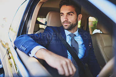 Buy stock photo Shot of a confident young businessman contemplating while being seated in his car