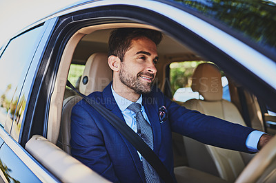 Buy stock photo Shot of a cheerful young businessman driving his car to work while looking onto the road