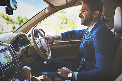 Buy stock photo Shot of a cheerful young businessman driving in his car to work while sitting in traffic