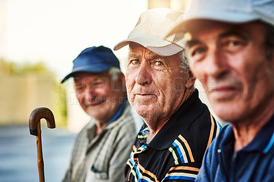 Buy stock photo Portrait of a group of cheerful senior men sitting together while looking into the camera outside