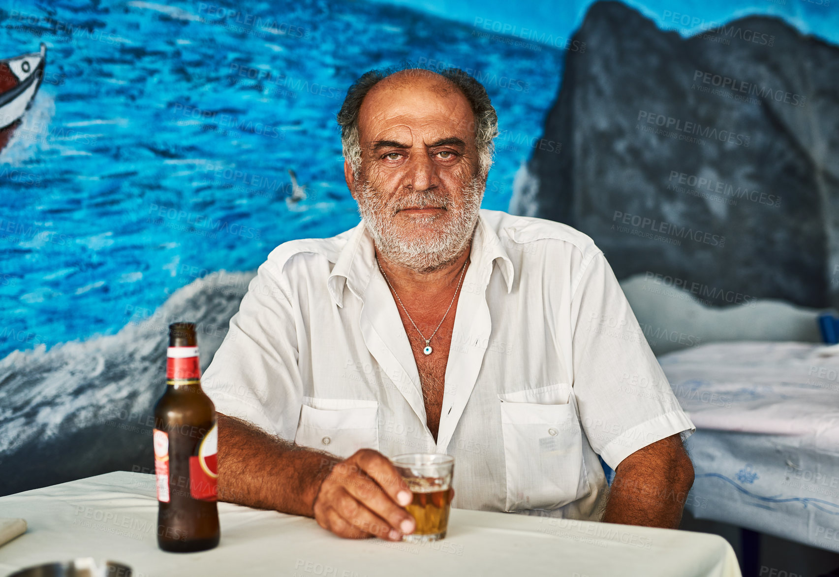 Buy stock photo Portrait of a confident senior man enjoying a beer while being seated in a cafe