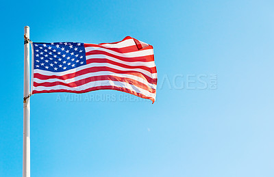Buy stock photo Low angle shot of the American flag standing on its own outside during the day
