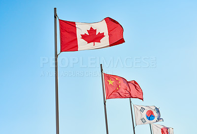 Buy stock photo Flag, diversity and blue sky for peace, culture and patriotic history or heritage event. International, unity and embassy with government, solidarity and national symbol flying in windy breeze