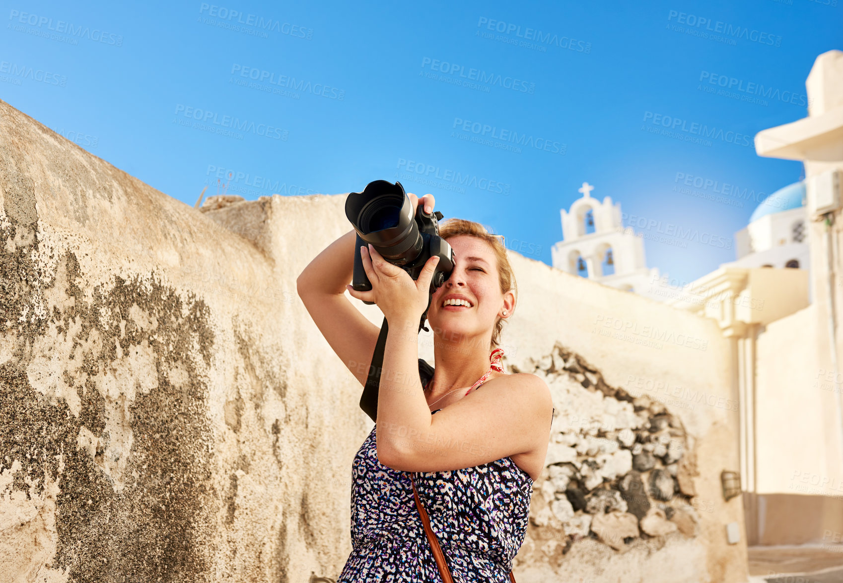 Buy stock photo Shot of a cheerful young woman taking photos of the area outside during the day