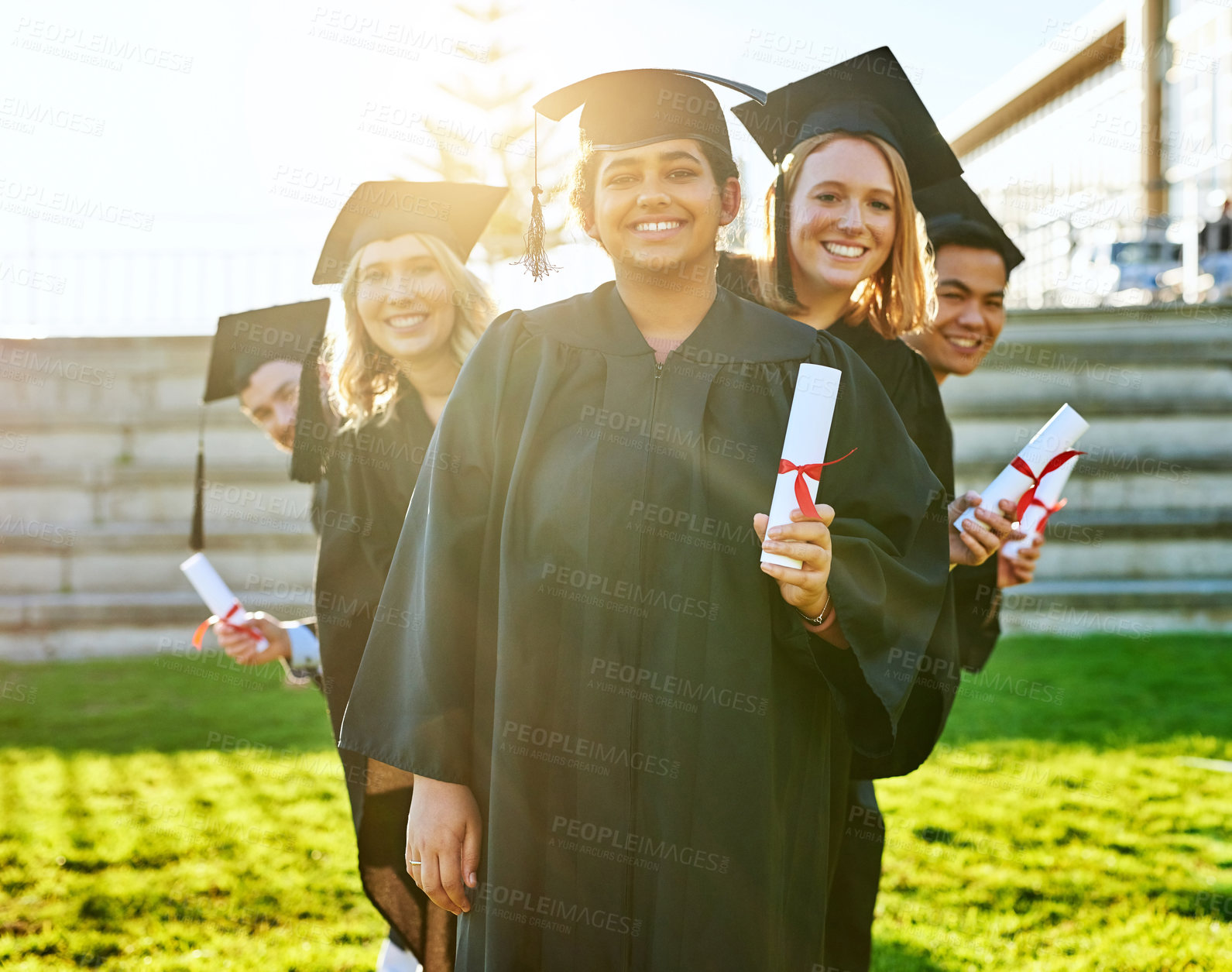 Buy stock photo Portrait of a group of students holding their diplomas on graduation day
