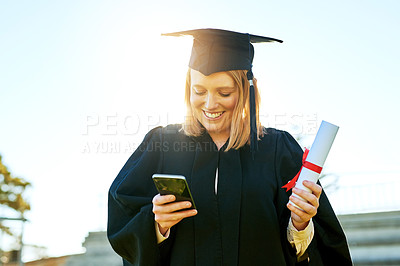 Buy stock photo Shot of student using her cellphone on graduation day
