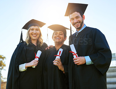 Buy stock photo Portrait of a group of students holding their diplomas on graduation day