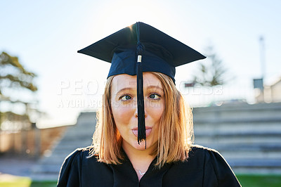 Buy stock photo Portrait of a student sticking out her tongue while wearing a graduation hat