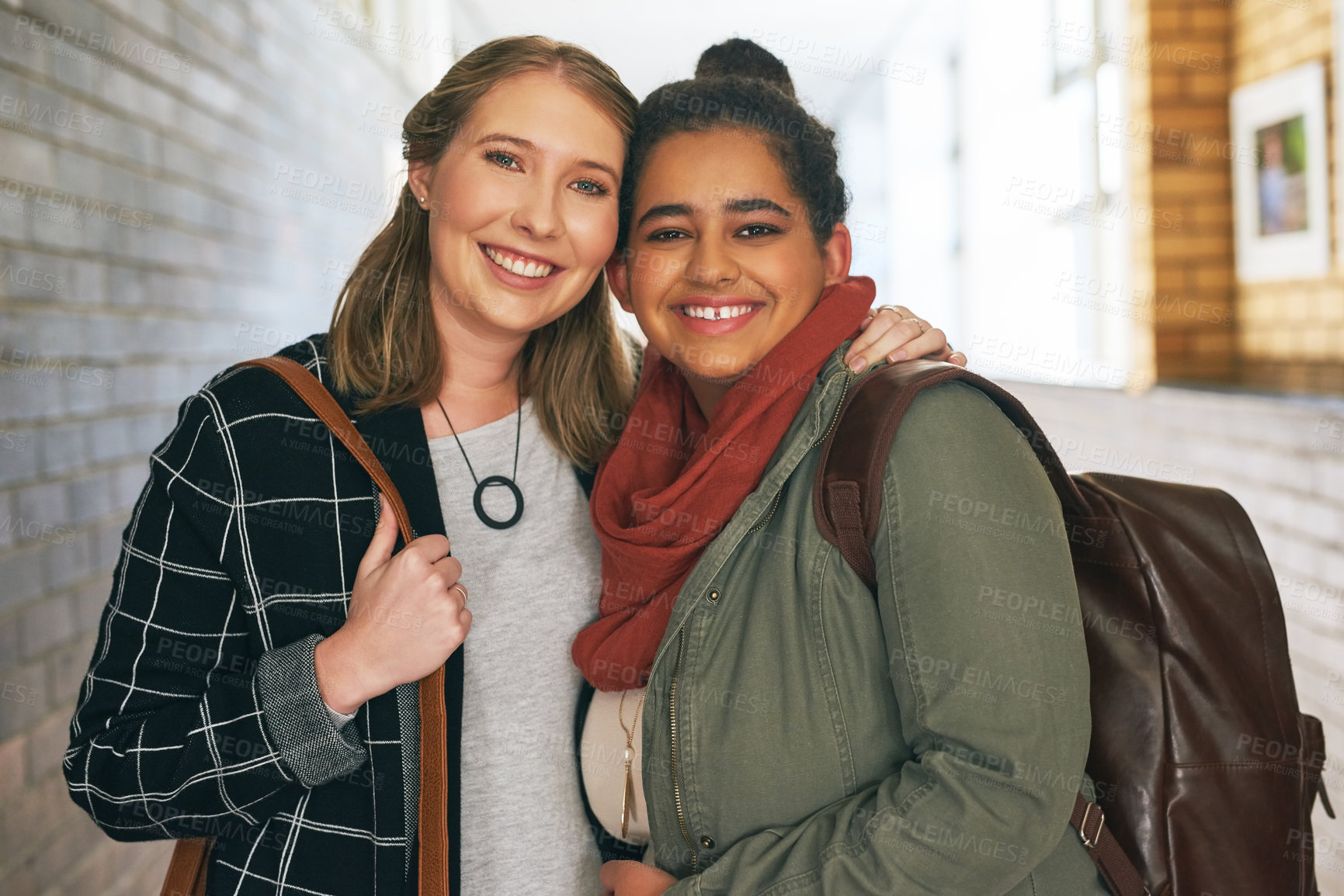 Buy stock photo Portrait of two attractive young female university students standing in a campus corridor