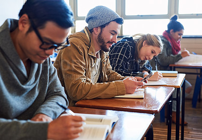 Buy stock photo Cropped shot of a group of university students working in class while sitting in a lecture