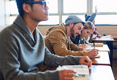 Buy stock photo Cropped shot of a group of university students working in class while sitting in a lecture