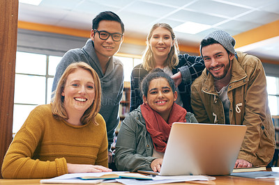 Buy stock photo Portrait of a cheerful young group of students working together using a laptop to study for exams inside of a library