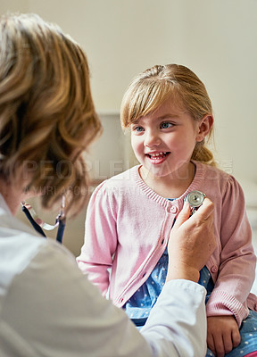 Buy stock photo Shot of a doctor examining a little girl with a stethoscope in her consulting room