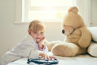 Buy stock photo Shot of an adorable little girl dressed up as a doctor and treating her teddy bear as a patient