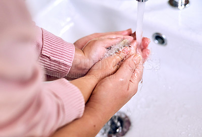 Buy stock photo Closeup of a unrecognizable parent and child washing their hands together under a tap inside at home