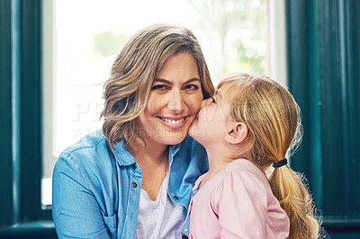 Buy stock photo Portrait of a cheerful young mother receiving a kiss on the cheek by her young little daughter