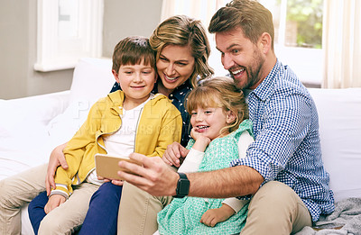 Buy stock photo Shot of a family taking a selfie at home