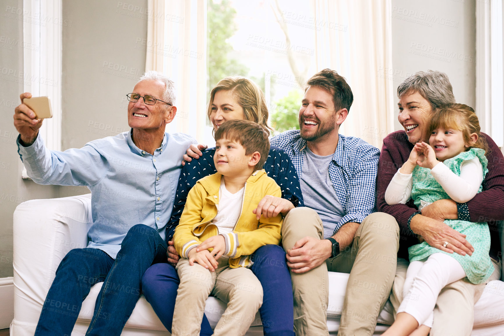 Buy stock photo Shot of a multigenerational family sitting on the sofa at home