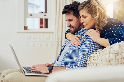 Buy stock photo Shot of an attractive couple using a laptop together at home