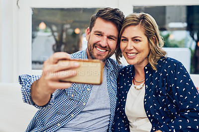 Buy stock photo Shot of an attractive couple taking a selfie at home