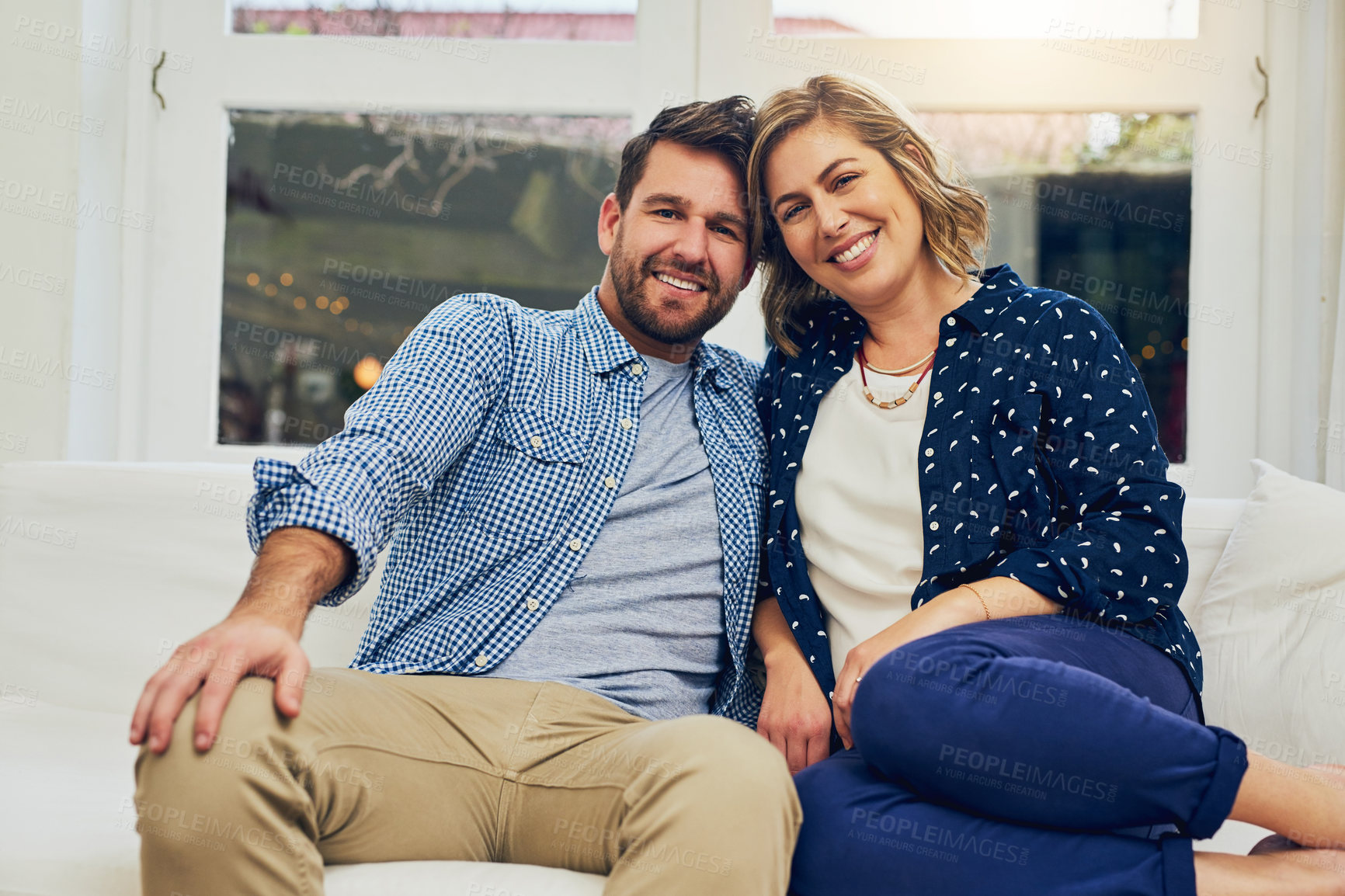 Buy stock photo Happy couple, portrait and relax with sofa for bonding, weekend or fun holiday together at home. Young man, woman or lovers with smile on couch for relationship, marriage or commitment at house