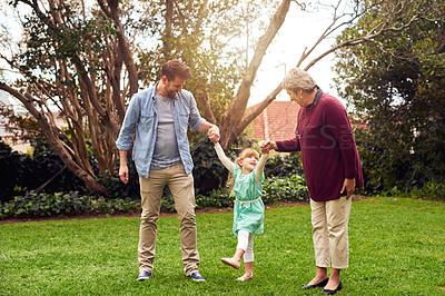 Buy stock photo Holding hands, daughter swinging with dad and granny in garden of home together for bonding or visit. Fun, love or smile with family of girl, parent and senior woman outdoor in nature for excitement