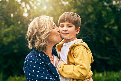 Buy stock photo Shot of a mother kissing her son on the cheek outside