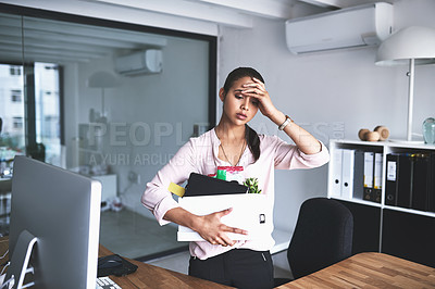 Buy stock photo Shot of an unhappy businesswoman holding her box of belongings after getting fired from her job