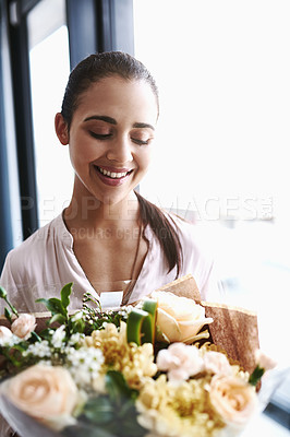 Buy stock photo Shot of a young businesswoman holding a bouquet of flowers