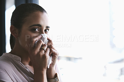 Buy stock photo Portrait of a young businesswoman blowing her nose in an office