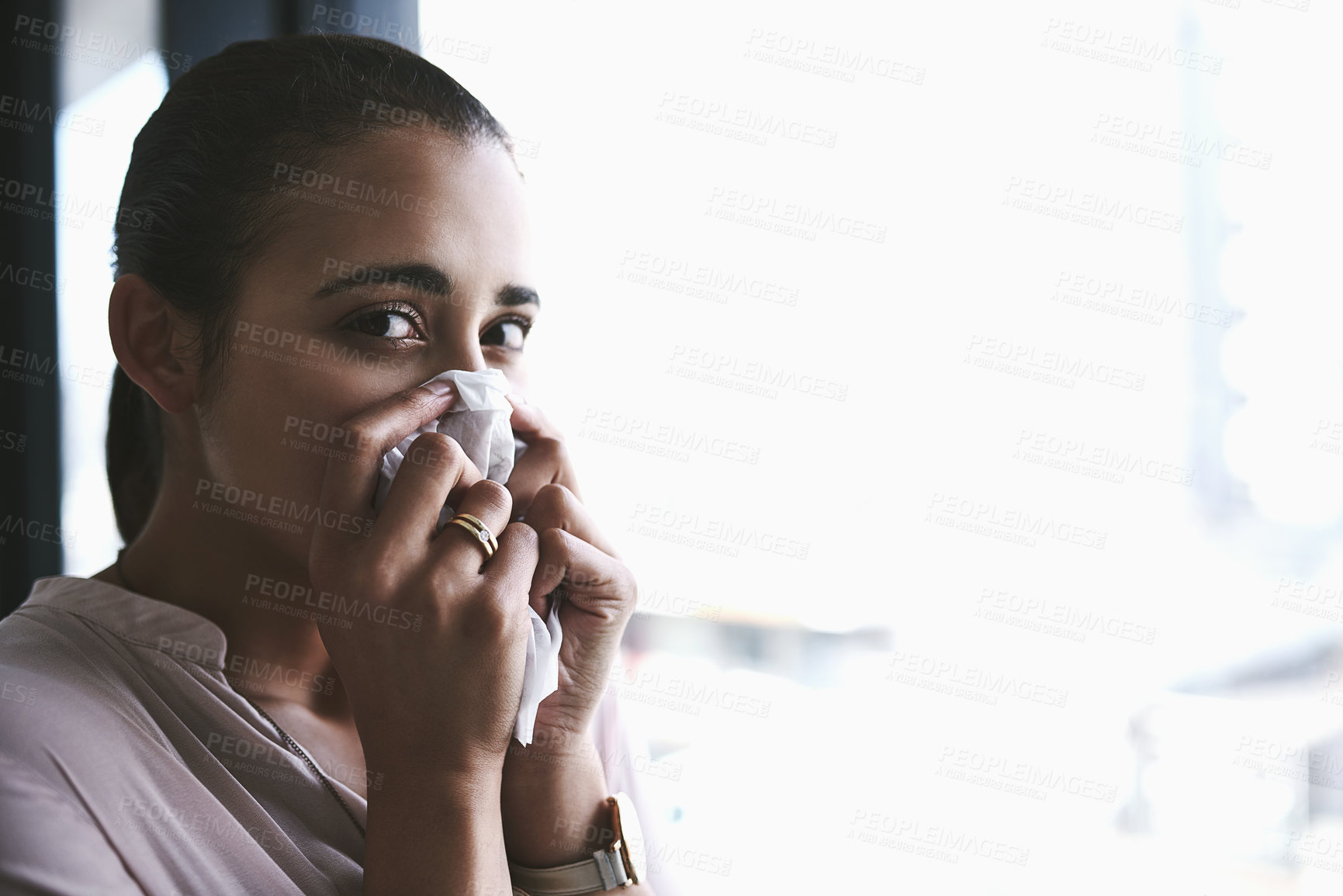 Buy stock photo Portrait of a young businesswoman blowing her nose in an office