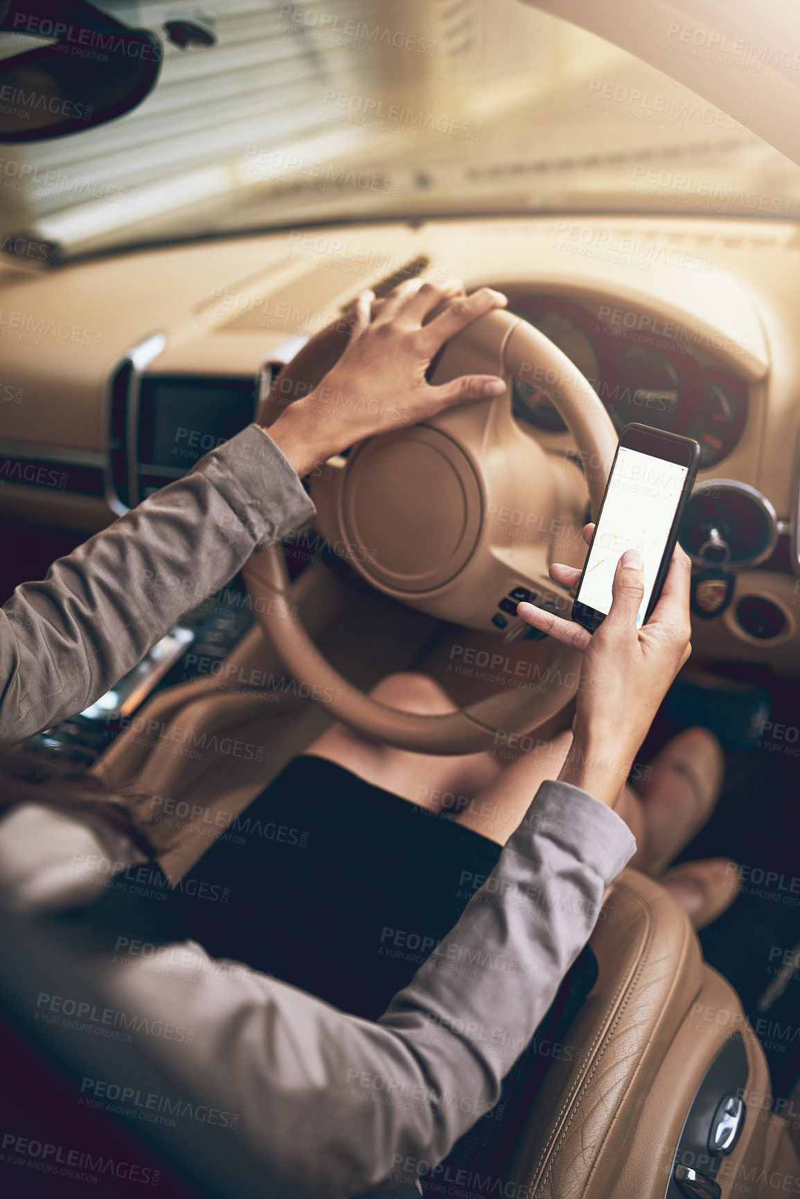 Buy stock photo Shot of an unidentifiable businesswoman using a cellphone while driving a car