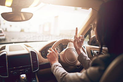 Buy stock photo Shot of an unidentifiable businesswoman showing her middle finger while driving a car