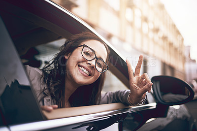 Buy stock photo Portrait of a young businesswoman showing a peace sign while leaning out the window of a car