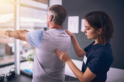 Buy stock photo Cropped shot of a young female physiotherapist treating a mature male patient