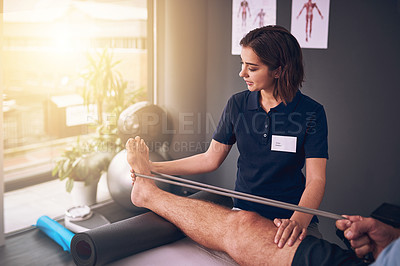 Buy stock photo Cropped shot of an attractive young female physiotherapist treating a male patient