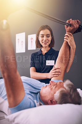 Buy stock photo Cropped shot of a young female physiotherapist treating a mature male patient