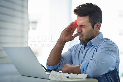 Buy stock photo Shot of a young businessman suffering with a headache at work