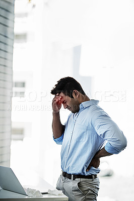 Buy stock photo Shot of a young businessman suffering with a headache and back pain at work