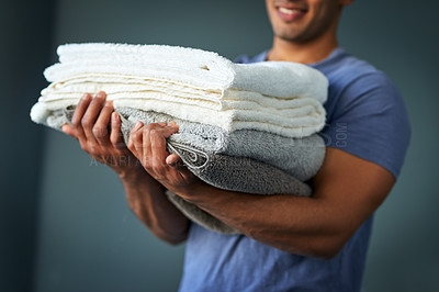 Buy stock photo Hands, laundry and pile with man in studio on gray background for chores or spring cleaning. Fabric, linen and towel stack with cleaner person carrying washing for hygiene or responsibilities