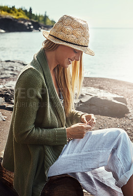 Buy stock photo Shot of a young woman spending a day at the lake