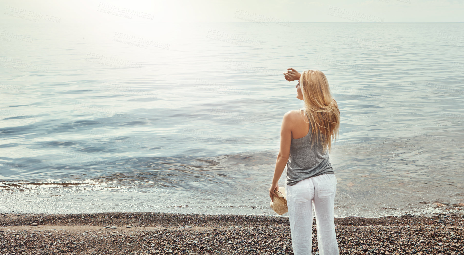 Buy stock photo Shot of a young woman spending a day at the lake