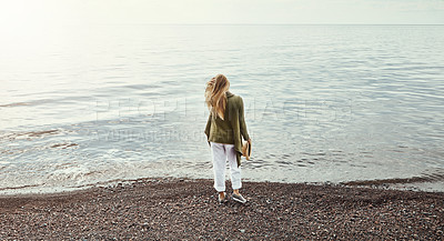 Buy stock photo Shot of a young woman spending a day at the lake